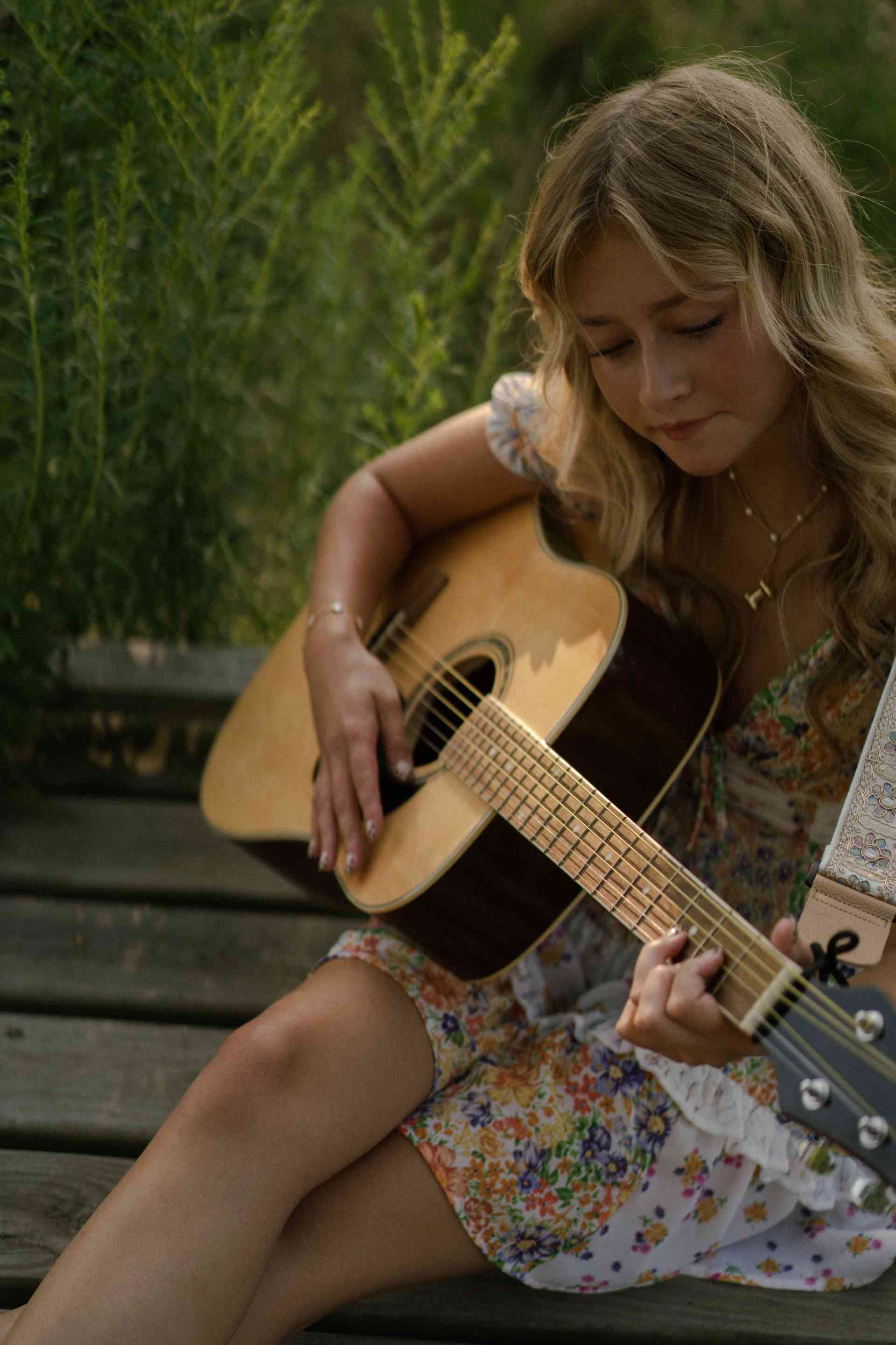 A blonde playing the guitar.